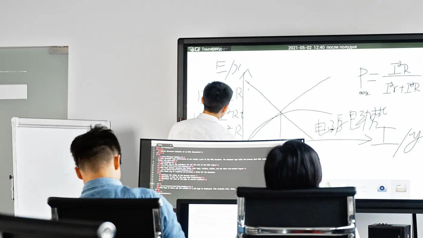 A team working through a plan at a whiteboard