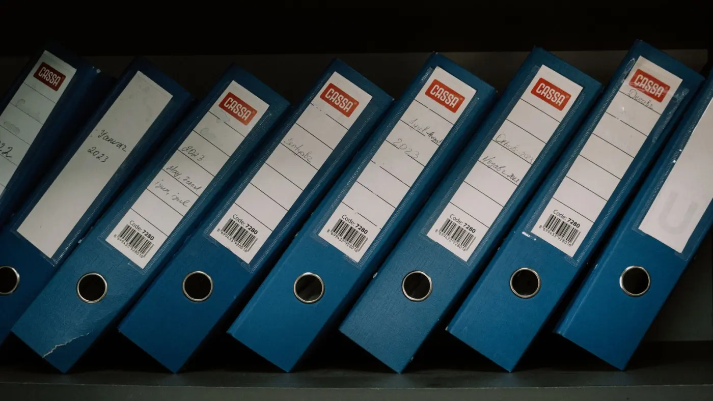 Labelled office binders arranged on a shelf